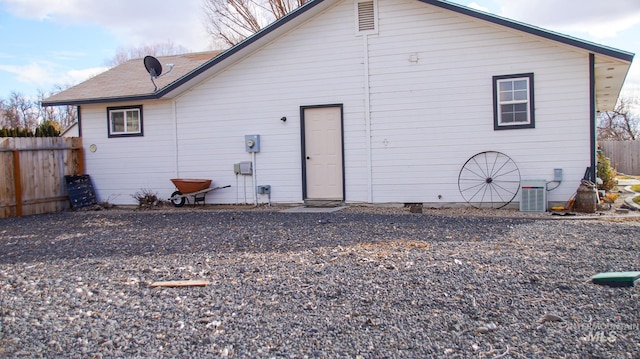 back of property featuring crawl space, roof with shingles, fence, and central AC unit