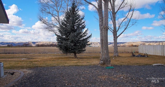 view of yard featuring fence and a rural view