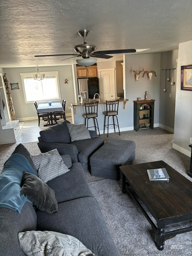 living room featuring light carpet, a textured ceiling, and ceiling fan