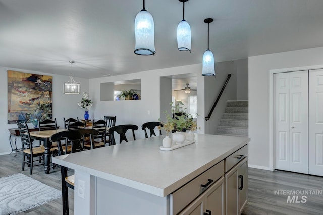 kitchen featuring light countertops, a center island, a breakfast bar area, and light wood finished floors