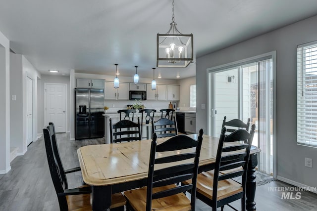 dining area featuring baseboards, dark wood-style flooring, and an inviting chandelier