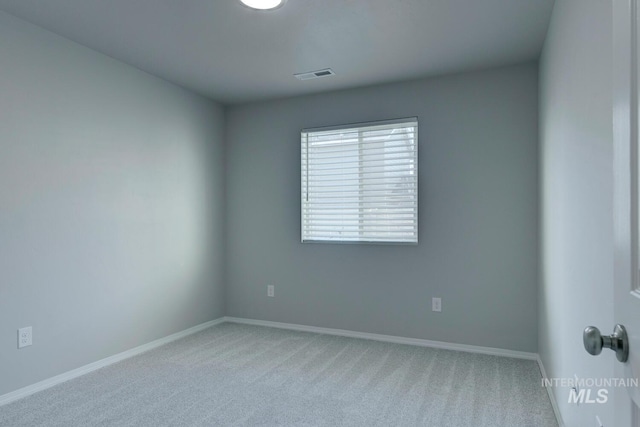 carpeted empty room featuring baseboards and visible vents
