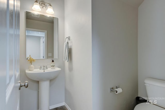 half bathroom with toilet and baseboards