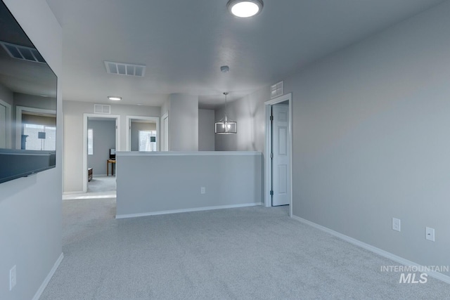 empty room with baseboards, visible vents, and carpet