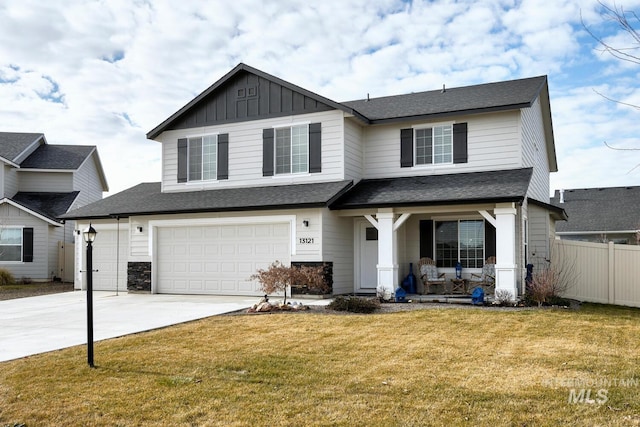 view of front of property with a front yard, concrete driveway, fence, an attached garage, and board and batten siding