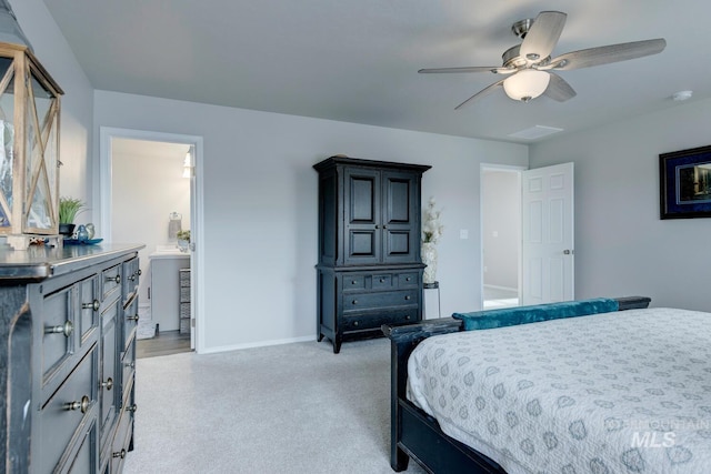bedroom with light carpet, ensuite bathroom, baseboards, and ceiling fan