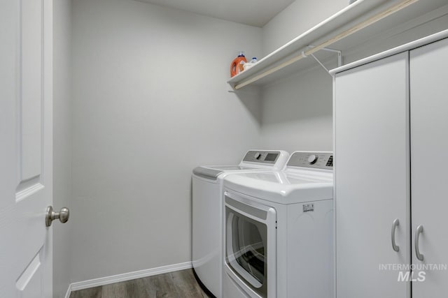 washroom with baseboards, washing machine and dryer, wood finished floors, and laundry area