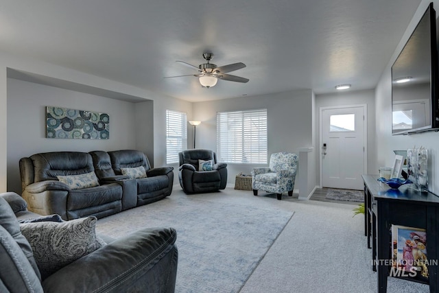 carpeted living room featuring a ceiling fan and baseboards