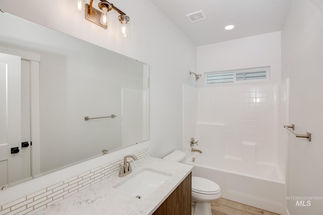 full bathroom featuring hardwood / wood-style flooring, vanity, toilet, and bathing tub / shower combination