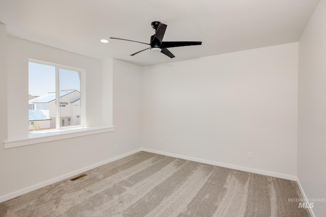 carpeted spare room with ceiling fan