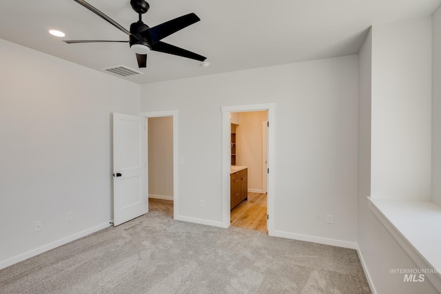 unfurnished bedroom featuring connected bathroom, ceiling fan, and light carpet