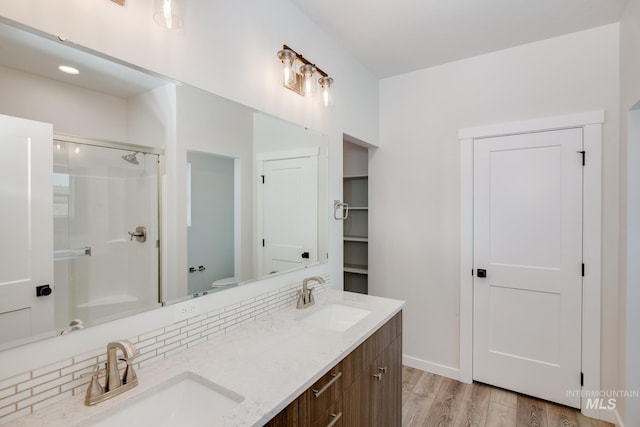 bathroom featuring decorative backsplash, vanity, hardwood / wood-style flooring, and toilet