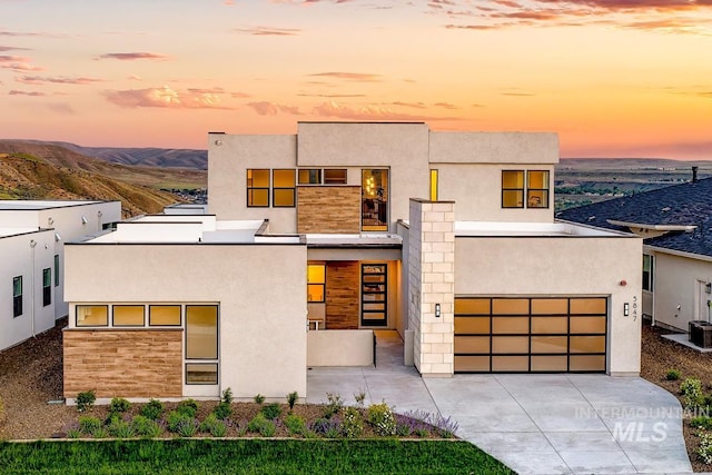 contemporary home featuring a garage and central AC unit