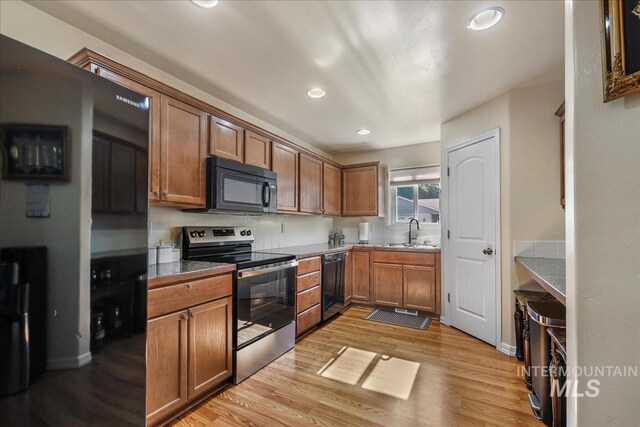1128 W Wirsching Ave, Twin Falls, ID 83301 - kitchen with black appliances, light wood-style flooring, brown cabinetry, and recessed lighting