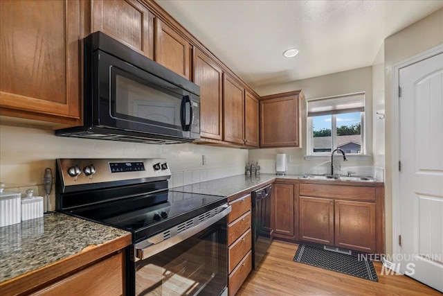 1128 W Wirsching Ave, Twin Falls, ID 83301 - kitchen featuring black appliances, light wood finished floors, brown cabinetry, and dark countertops