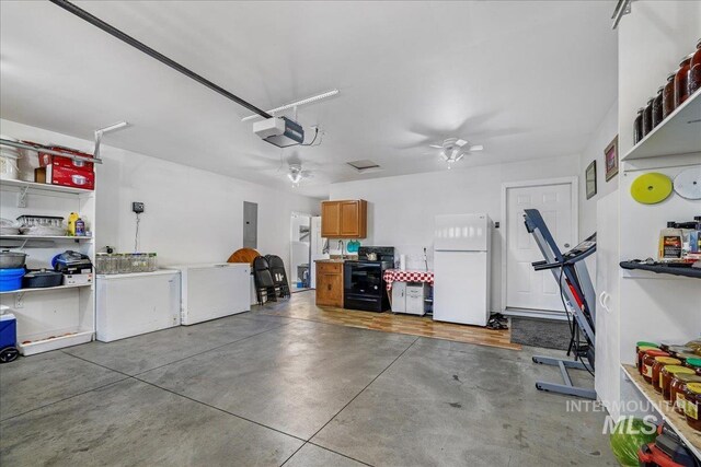 1128 W Wirsching Ave, Twin Falls, ID 83301 - garage featuring freestanding refrigerator, a garage door opener, electric panel, and refrigerator