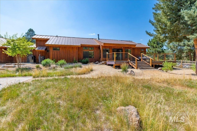 view of front of house featuring central AC unit and a wooden deck