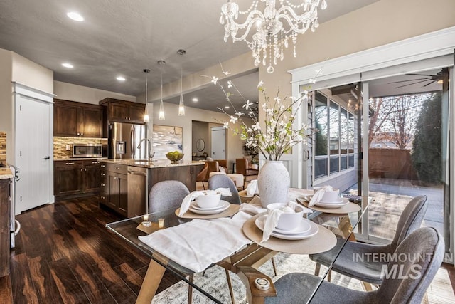 dining space featuring ceiling fan with notable chandelier and dark hardwood / wood-style floors