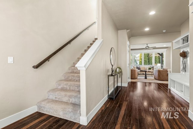 stairs with hardwood / wood-style floors and ceiling fan