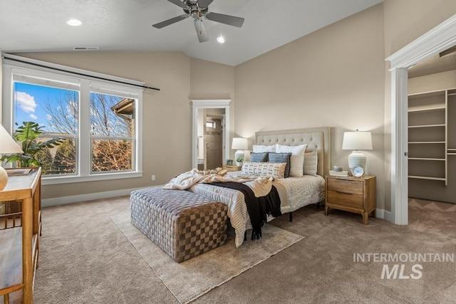 bedroom with a walk in closet, vaulted ceiling, ceiling fan, light colored carpet, and a closet