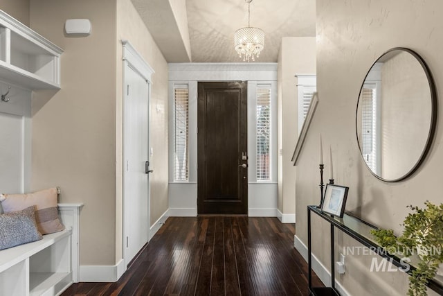 foyer with dark hardwood / wood-style flooring and a chandelier