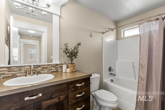 full bathroom featuring vanity, toilet, backsplash, and shower / tub combo with curtain