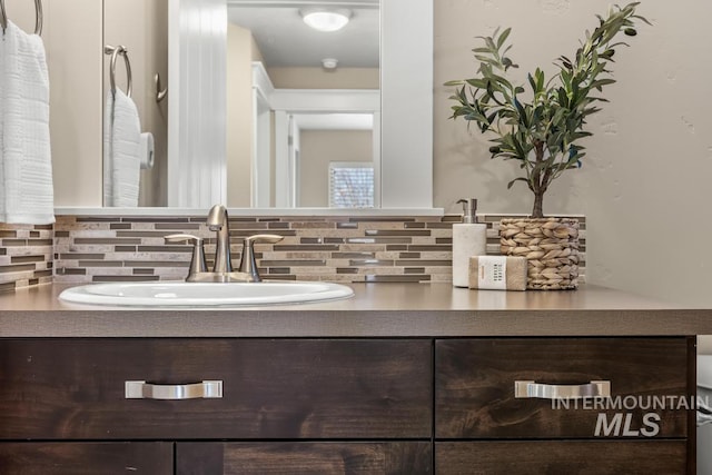 bathroom with tasteful backsplash and vanity