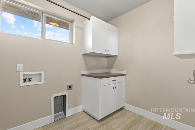 clothes washing area with electric dryer hookup, cabinets, hookup for a washing machine, and light hardwood / wood-style floors