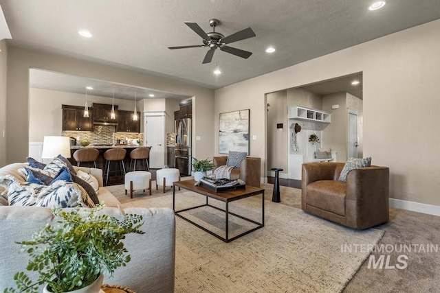 carpeted living room with ceiling fan