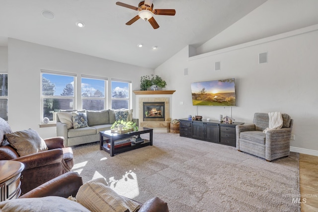 living area featuring a ceiling fan, baseboards, visible vents, high vaulted ceiling, and a fireplace