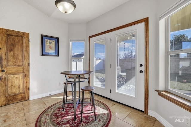 doorway with light tile patterned floors and baseboards