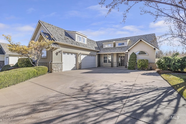 view of front of house with stucco siding, stone siding, concrete driveway, and an attached garage