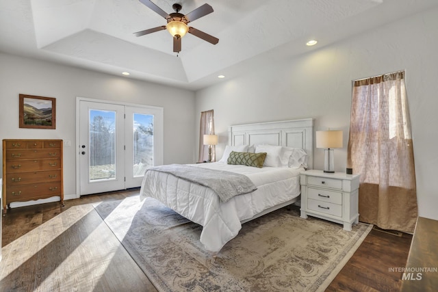 bedroom featuring a ceiling fan, wood finished floors, recessed lighting, a raised ceiling, and access to outside