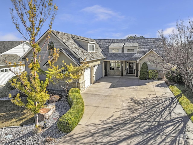 view of front of home with an attached garage, stone siding, and driveway