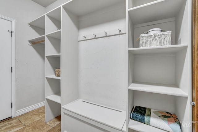 mudroom with baseboards and stone finish floor