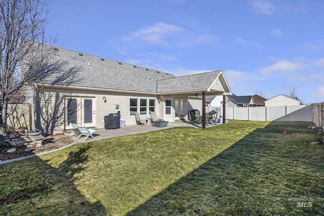 rear view of house featuring a lawn, a patio, and a fenced backyard