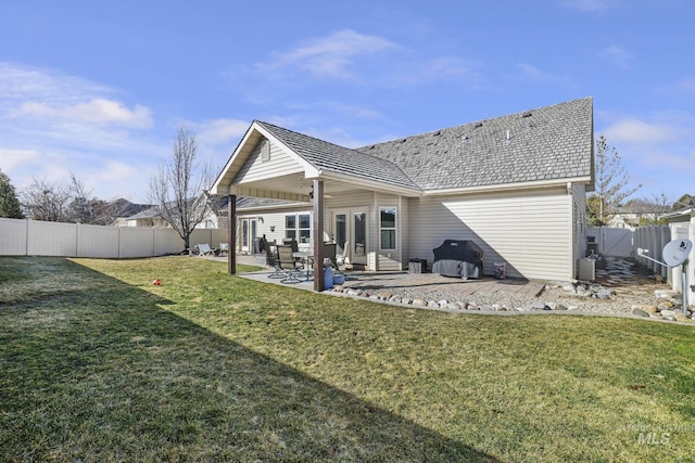 rear view of house with a patio area, a lawn, and a fenced backyard