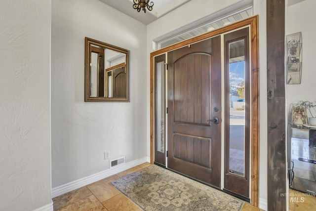 entrance foyer featuring visible vents, baseboards, and a textured wall