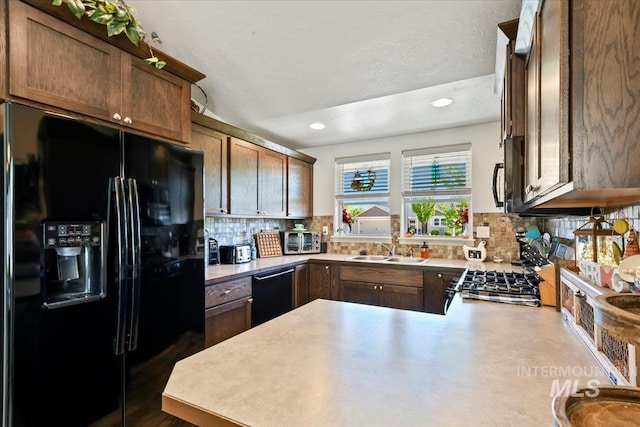 5416 Junegrass Way, Caldwell, ID 83607 - kitchen with black appliances, a sink, decorative backsplash, a peninsula, and recessed lighting