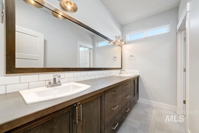 bathroom with double vanity, tasteful backsplash, and a sink