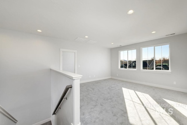 carpeted empty room featuring baseboards, visible vents, and recessed lighting