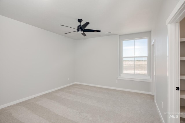 carpeted empty room featuring ceiling fan