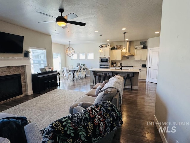 805 Drayton Ave, Twin Falls, ID 83301 - living area featuring a ceiling fan, dark wood-type flooring, a fireplace, baseboards, and recessed lighting