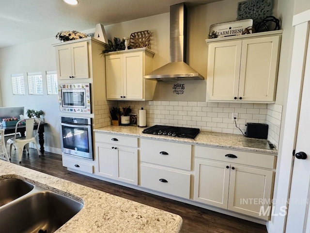 805 Drayton Ave, Twin Falls, ID 83301 - kitchen with appliances with stainless steel finishes, wall chimney range hood, dark wood-style flooring, and decorative backsplash