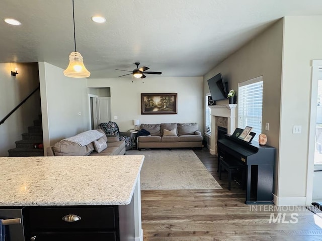 805 Drayton Ave, Twin Falls, ID 83301 - living area featuring wood finished floors, a fireplace, ceiling fan, stairs, and recessed lighting