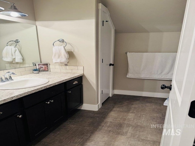 805 Drayton Ave, Twin Falls, ID 83301 - bathroom with vanity, baseboards, tasteful backsplash, and wood finished floors