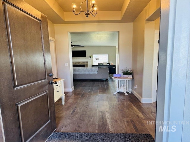 805 Drayton Ave, Twin Falls, ID 83301 - entrance foyer with a raised ceiling, a chandelier, dark wood finished floors, baseboards, and a fireplace