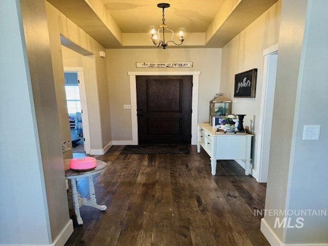 805 Drayton Ave, Twin Falls, ID 83301 - foyer entrance with a chandelier, dark wood-type flooring, a raised ceiling, and baseboards