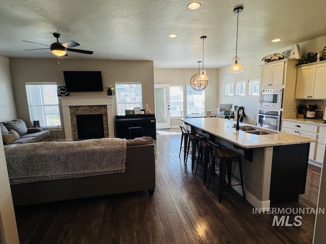 805 Drayton Ave, Twin Falls, ID 83301 - living area featuring dark wood-style flooring, healthy amount of natural light, a fireplace, ceiling fan, and a textured ceiling