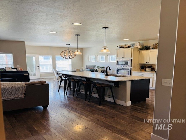 805 Drayton Ave, Twin Falls, ID 83301 - kitchen featuring stainless steel appliances, a sink, a kitchen bar, open floor plan, and a center island with sink
